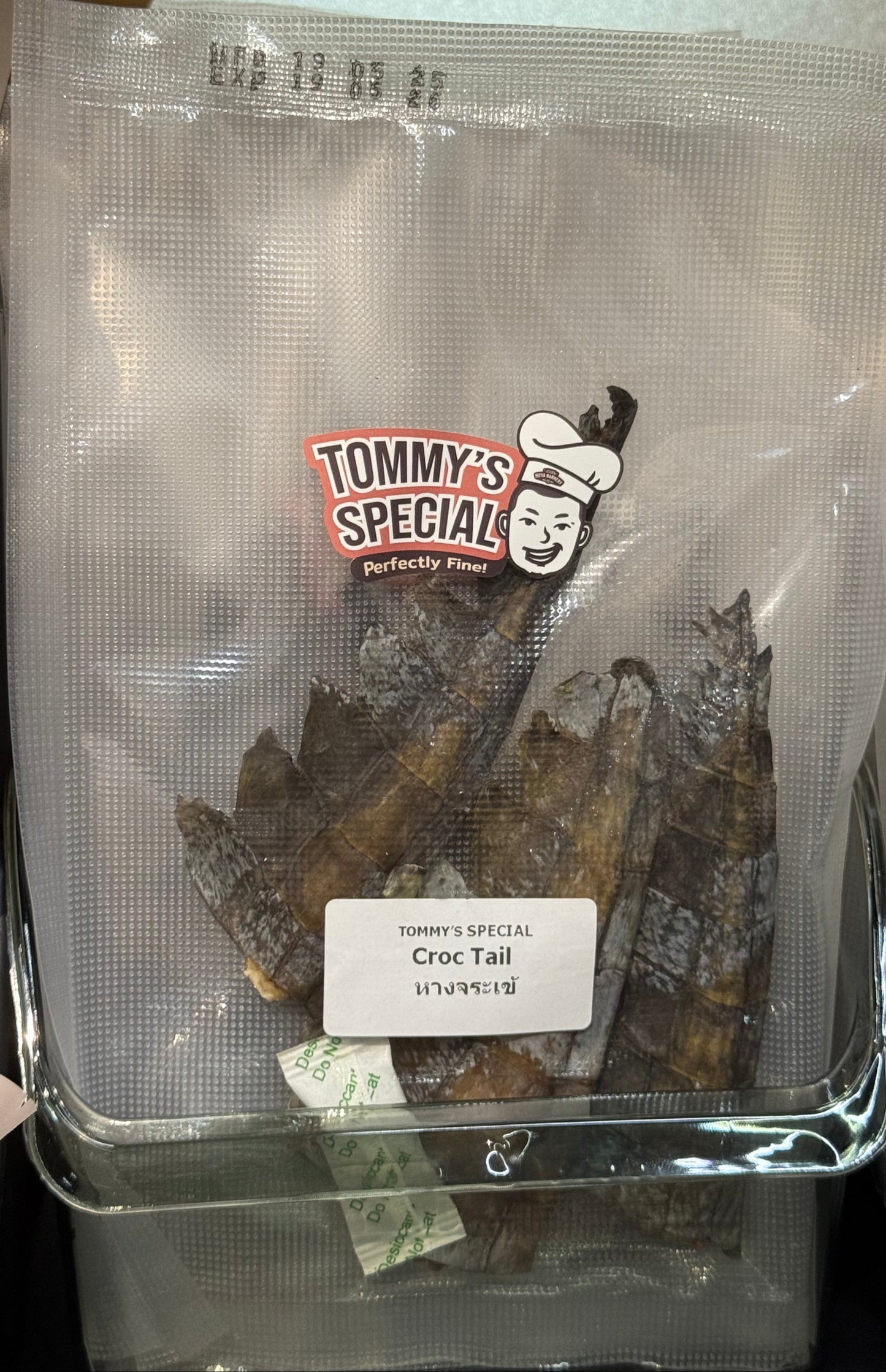 package of Tommy's Special Croc Tail pet treats, showing the dried crocodile tail pieces inside the clear bag with the brand label.