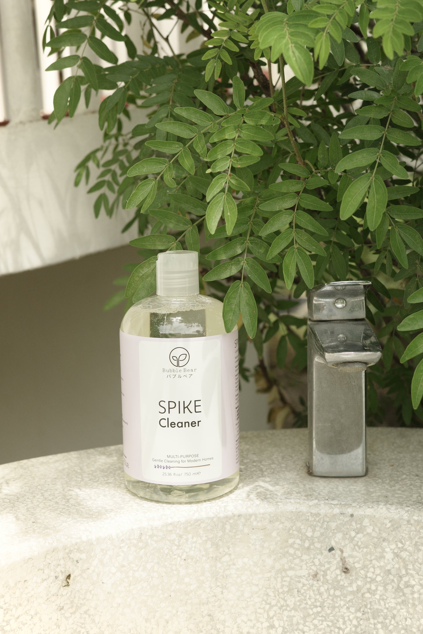 Bottle of Spike Cleaner on a surface with greenery in the background