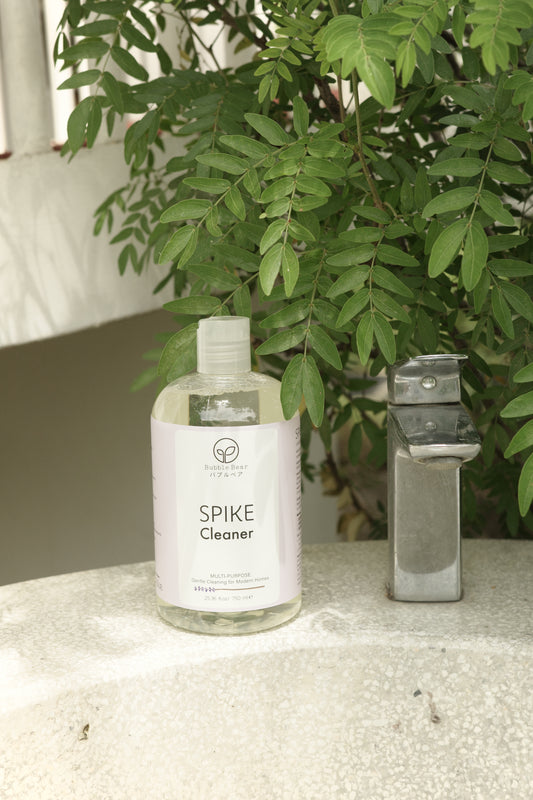 Bottle of Spike Cleaner on a surface with greenery in the background